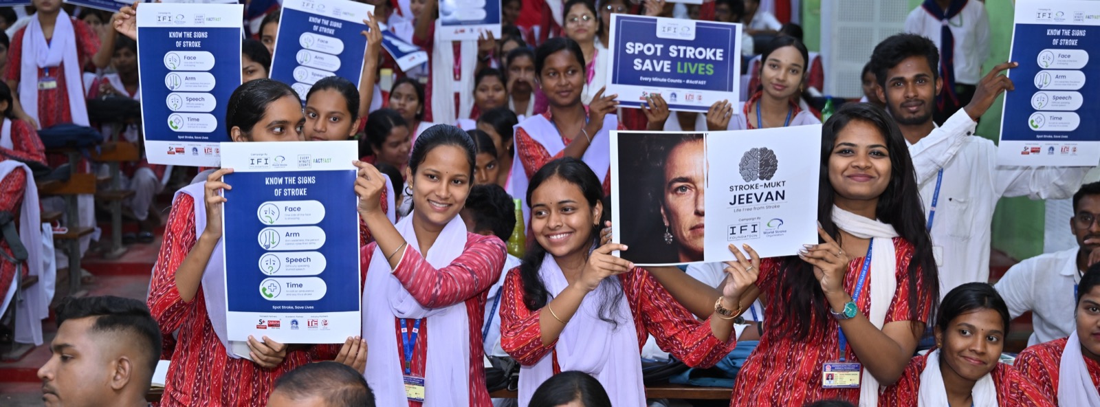 University students holding stroke awareness and FAST symptom recognition cards during a Stroke Mukt Jeevan 3.0 campus event